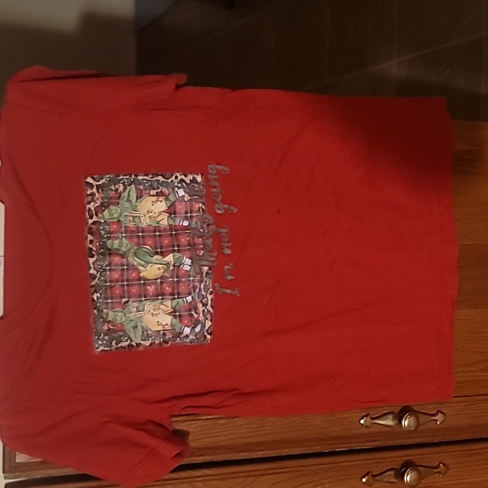 A christmas theme T-shirt with a design of the Grinch.